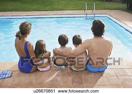 Family with three children (6-11) sitting by pool back view View Large Photo Image Stock Image - Family with three children (6-11) sitting by pool back view. Fotosearch