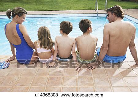 Family with three children (6-11) sitting by pool back view View Large Photo Image Stock Photo - Family with three children (6-11) sitting by pool back view. Fotosearch