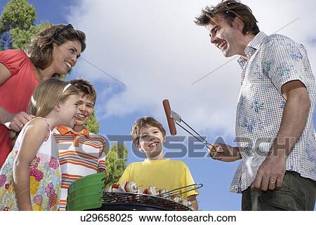Family with three children (6-11) grilling in garden View Large Photo Image Stock Photography - Family with three children (6-11) grilling in garden. Fotosearch