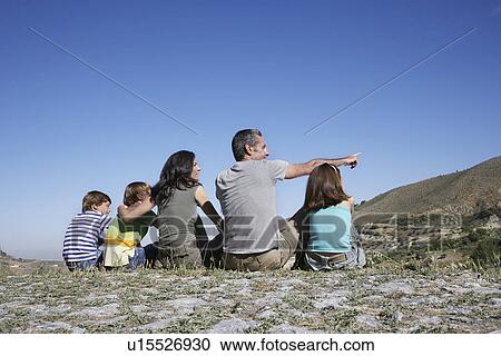 Family with three children (7-12) sitting on mountain top back view View Large Photo Image Stock Image - Family with three children (7-12) sitting on mountain top back view. Fotosearch