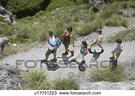 Family with three children (7-12) walking along path elevated view View Large Photo Image Stock Image - Family with three children (7-12) walking along path elevated view. Fotosearch