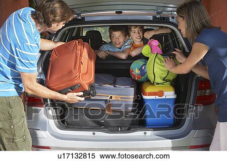 Stock Photography - Family with two sons (6-11) loading car trunk with luggage. Fotosearch