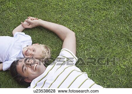 Father and young son (3-4) lying on grass portrait View Large Photo Image Stock Photo - Father and young son (3-4) lying on grass portrait. Fotosearch
