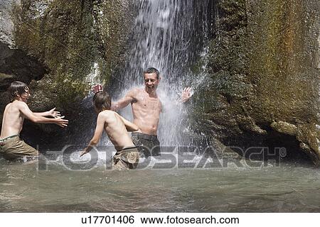 Father with sons (7-12) playing in river View Large Photo Image Stock Photograph - Father with sons (7-12) playing in river. Fotosearch
