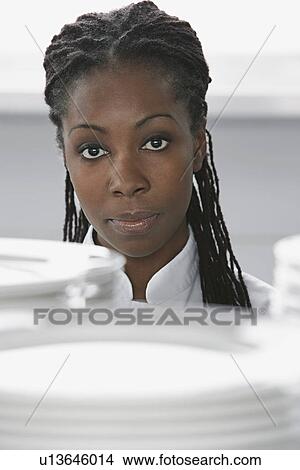 Picture - Female chef near stacked plates in kitchen portrait. Fotosearch