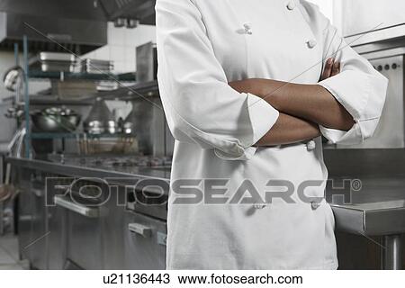 Female chef with arms crossed in kitchen mid section View Large Photo Image Stock Image - Female chef with arms crossed in kitchen mid section. Fotosearch