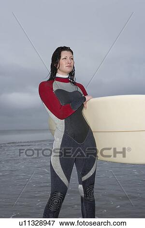 Female surfer carrying surfboard through shallow water View Large Photo Image Stock Photo - Female surfer carrying surfboard through shallow water. Fotosearch