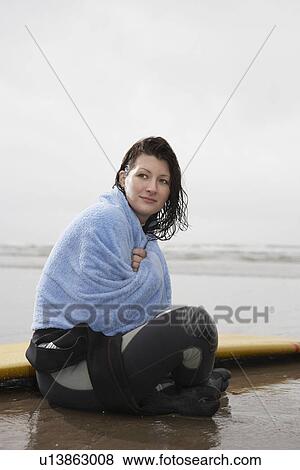 Female surfer sitting in shallow water covered with towel View Large Photo Image Stock Photo - Female surfer sitting in shallow water covered with towel. Fotosearch