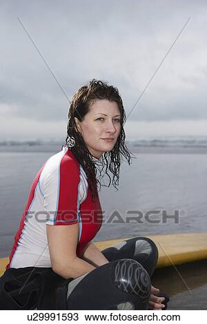 Female surfer sitting near surfboard in shallow water portrait side view View Large Photo Image Stock Image - Female surfer sitting near surfboard in shallow water portrait side view. Fotosearch