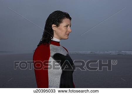 Female surfer standing in shallow water looking at sea at dusk side view View Large Photo Image Stock Image - Female surfer standing in shallow water looking at sea at dusk side view. Fotosearch