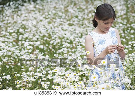 Stock Photo - Girl (7-9) in meadow full of flowers. Fotosearch