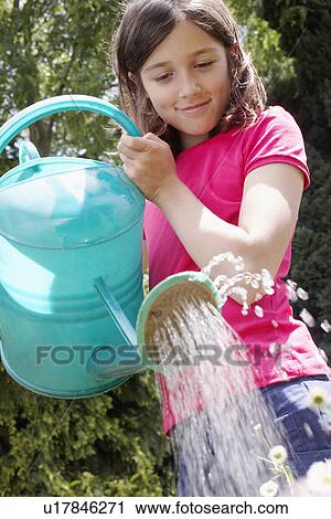 Girl (7-9) watering garden View Large Photo Image Stock Image - Girl (7-9) watering garden. Fotosearch