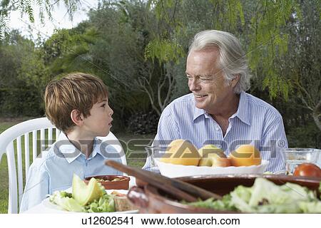 Grandfather and grandson (5-6) at garden table View Large Photo Image Stock Image - Grandfather and grandson (5-6) at garden table. Fotosearch