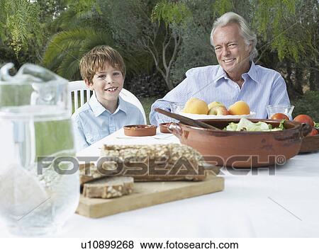 Grandfather and grandson (5-6) at garden table portrait View Large Photo Image Stock Photo - Grandfather and grandson (5-6) at garden table portrait. Fotosearch