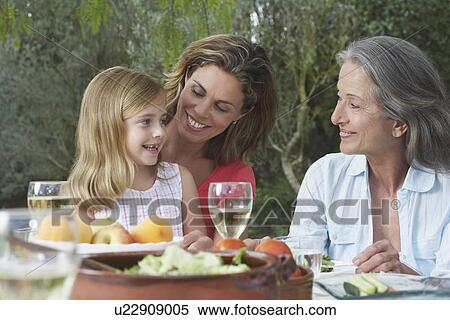 Grandmother mother and daughter (5-6) sitting at table in garden View Large Photo Image Stock Photography - Grandmother mother and daughter (5-6) sitting at table in garden. Fotosearch