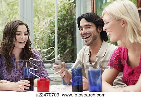 Group of young people sitting at verandah table View Large Photo Image Stock Photo - Group of young people sitting at verandah table. Fotosearch