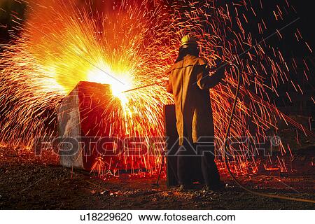 Industrial worker causing shower of sparks back view View Large Photo Image Stock Image - Industrial worker causing shower of sparks back view. Fotosearch