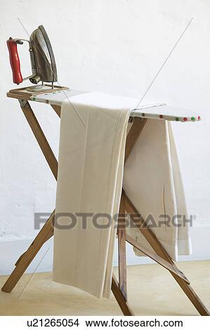 Picture - Iron and fabric on ironing board. Fotosearch