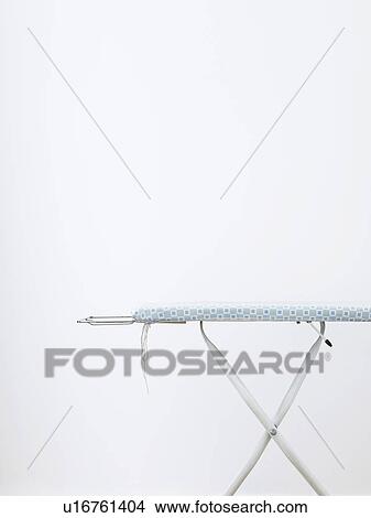 Ironing board against white wall View Large Photo Image Picture - Ironing board against white wall. Fotosearch