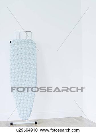 Ironing board against white wall View Large Photo Image Stock Image - Ironing board against white wall. Fotosearch