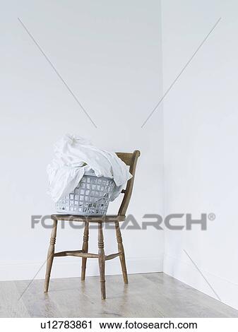 Laundry basket on chair in room View Large Photo Image Stock Image - Laundry basket on chair in room. Fotosearch