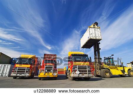 Lift truck loading shipping containers onto trucks View Large Photo Image Stock Photo - Lift truck loading shipping containers onto trucks. Fotosearch