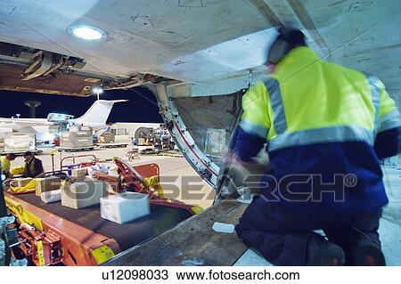 Loading freight into cargo hold of aircraft View Large Photo Image Stock Image - Loading freight into cargo hold of aircraft. Fotosearch