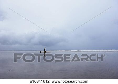 Lone surfer sitting on surfboard in shallow water side view View Large Photo Image Stock Image - Lone surfer sitting on surfboard in shallow water side view. Fotosearch