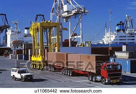 Stock Image - Machines in cargo container port. Fotosearch