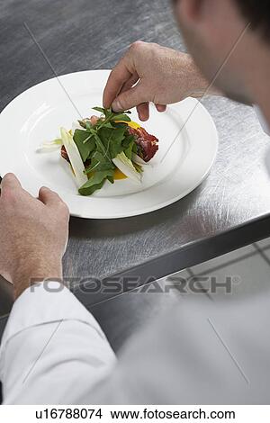Picture - Male chef preparing salad in kitchen. Fotosearch