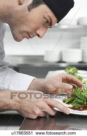 Male chef preparing salad in kitchen close-up View Large Photo Image Stock Image - Male chef preparing salad in kitchen close-up. Fotosearch