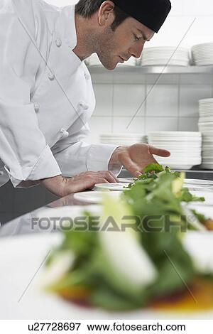 Stock Photo - Male chef preparing salad in kitchen. Fotosearch