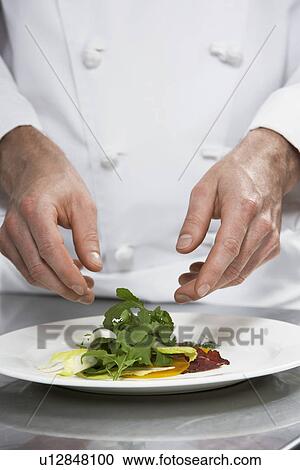 Stock Image - Male chef preparing salad mid section. Fotosearch