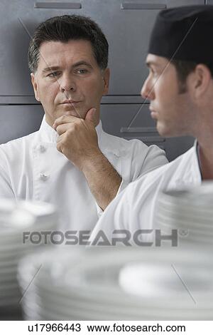 Male chef supervising trainee in kitchen View Large Photo Image Stock Image - Male chef supervising trainee in kitchen. Fotosearch