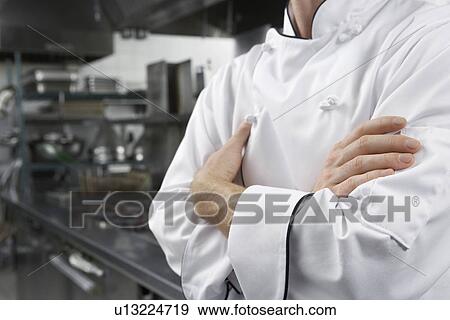 Male chef with arms crossed in kitchen mid section View Large Photo Image Stock Photo - Male chef with arms crossed in kitchen mid section. Fotosearch