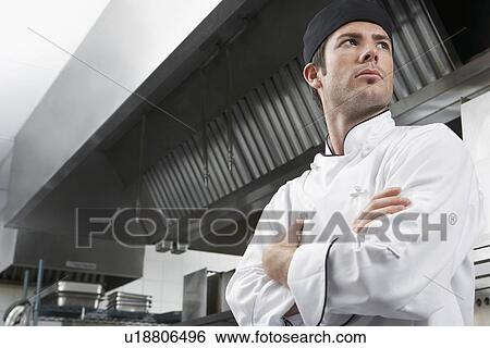 Male chef with arms crossed in kitchen low angle view View Large Photo Image Stock Photograph - Male chef with arms crossed in kitchen low angle view. Fotosearch
