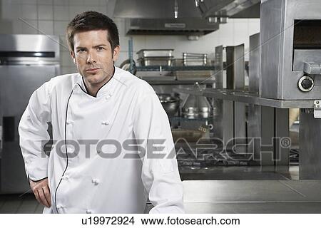 Male chef with hand on hip in kitchen portrait View Large Photo Image Picture - Male chef with hand on hip in kitchen portrait. Fotosearch