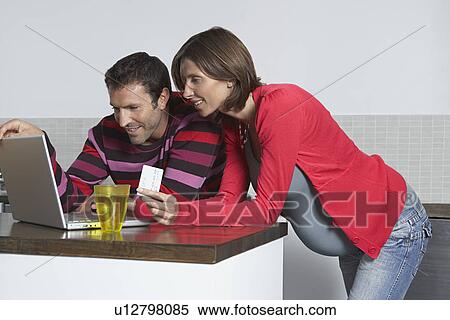 Man and pregnant woman using laptop to shop online at home View Large Photo Image Stock Photography - Man and pregnant woman using laptop to shop online at home. Fotosearch