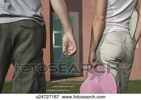 Man and woman in front of house man holding keys woman hat View Large Photo Image Stock Photo - Man and woman in front of house man holding keys woman hat. Fotosearch