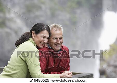 Man and woman in mountains looking down smiling View Large Photo Image Stock Photography - Man and woman in mountains looking down smiling. Fotosearch