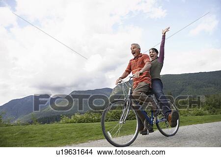 Man and woman riding on one bicycle screaming View Large Photo Image Picture - Man and woman riding on one bicycle screaming. Fotosearch