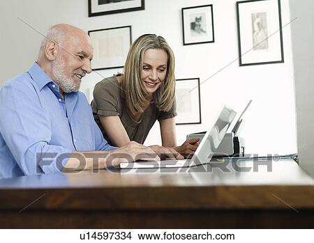 Man and woman using laptop at home View Large Photo Image Picture - Man and woman using laptop at home. Fotosearch
