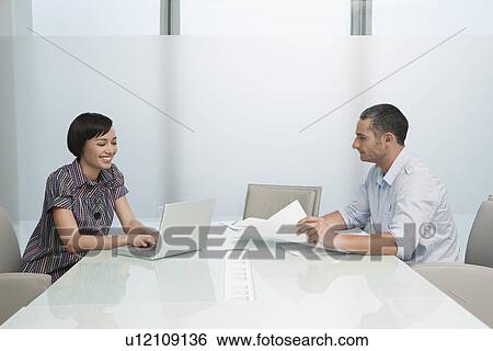 Man and woman working in conference room woman on laptop View Large Photo Image Stock Photograph - Man and woman working in conference room woman on laptop. Fotosearch