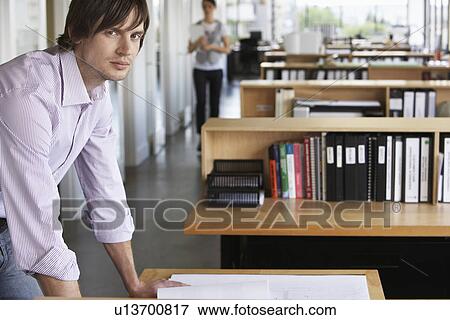 Man by desk in office portrait View Large Photo Image Stock Photo - Man by desk in office portrait. Fotosearch
