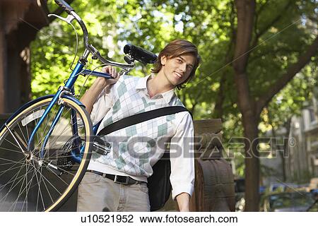 Man carrying bicycle descending steps View Large Photo Image Stock Image - Man carrying bicycle descending steps. Fotosearch