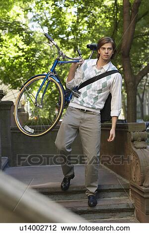 Man carrying bicycle descending steps View Large Photo Image Stock Image - Man carrying bicycle descending steps. Fotosearch