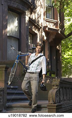 Man carrying bicycle descending steps View Large Photo Image Stock Image - Man carrying bicycle descending steps. Fotosearch