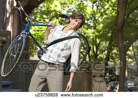 Man carrying bicycle descending steps View Large Photo Image Stock Photo - Man carrying bicycle descending steps. Fotosearch