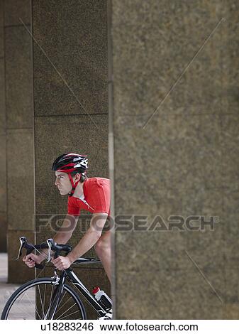 Man cycling between pillars View Large Photo Image Stock Photograph - Man cycling between pillars. Fotosearch