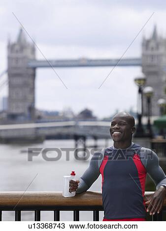 Man drinking water in front of Tower Bridge England London View Large Photo Image Stock Image - Man drinking water in front of Tower Bridge England London. Fotosearch